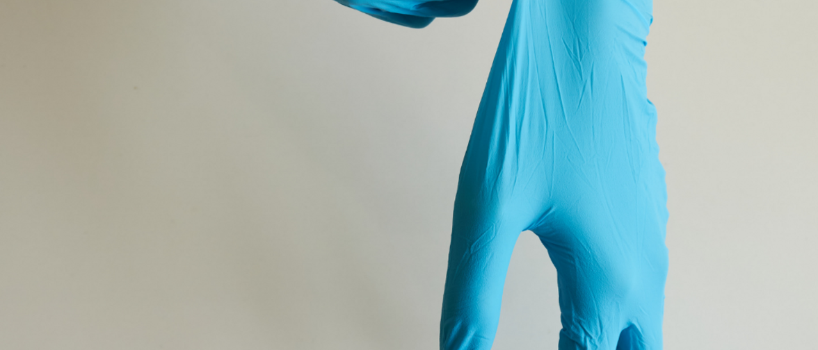 Hände mit blauen Desinfektionshandschuhen