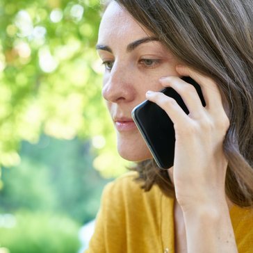 Eine ernst blickende Frau telefoniert.
