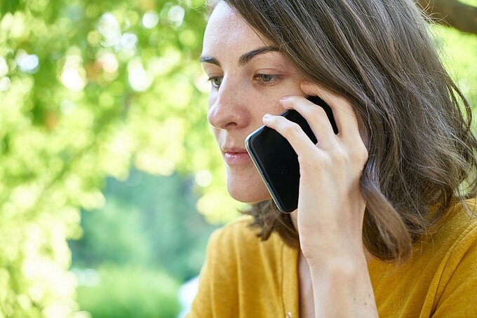 Krisendienst Psychiatrie Eine ernst blickende Frau telefoniert.