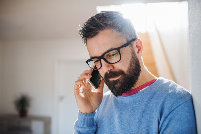 Krisendienst Psychiatrie Oberbayern Abgebildet ist ein Mann, der ein ernstes Telefongespräch führt.