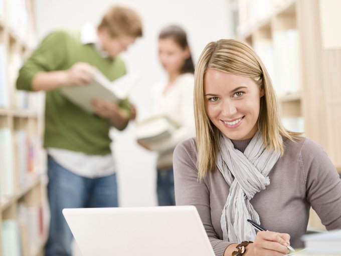 High school library - happy student with laptop