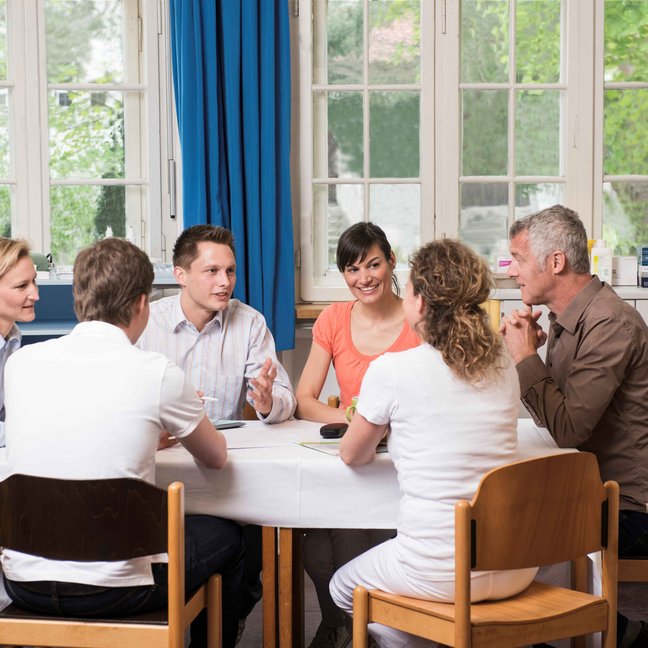 Auf dem Bild abgebildet sind Kolleginnen und Kollegen bei einer Teambesprechung in einer kbo-Klinik.
