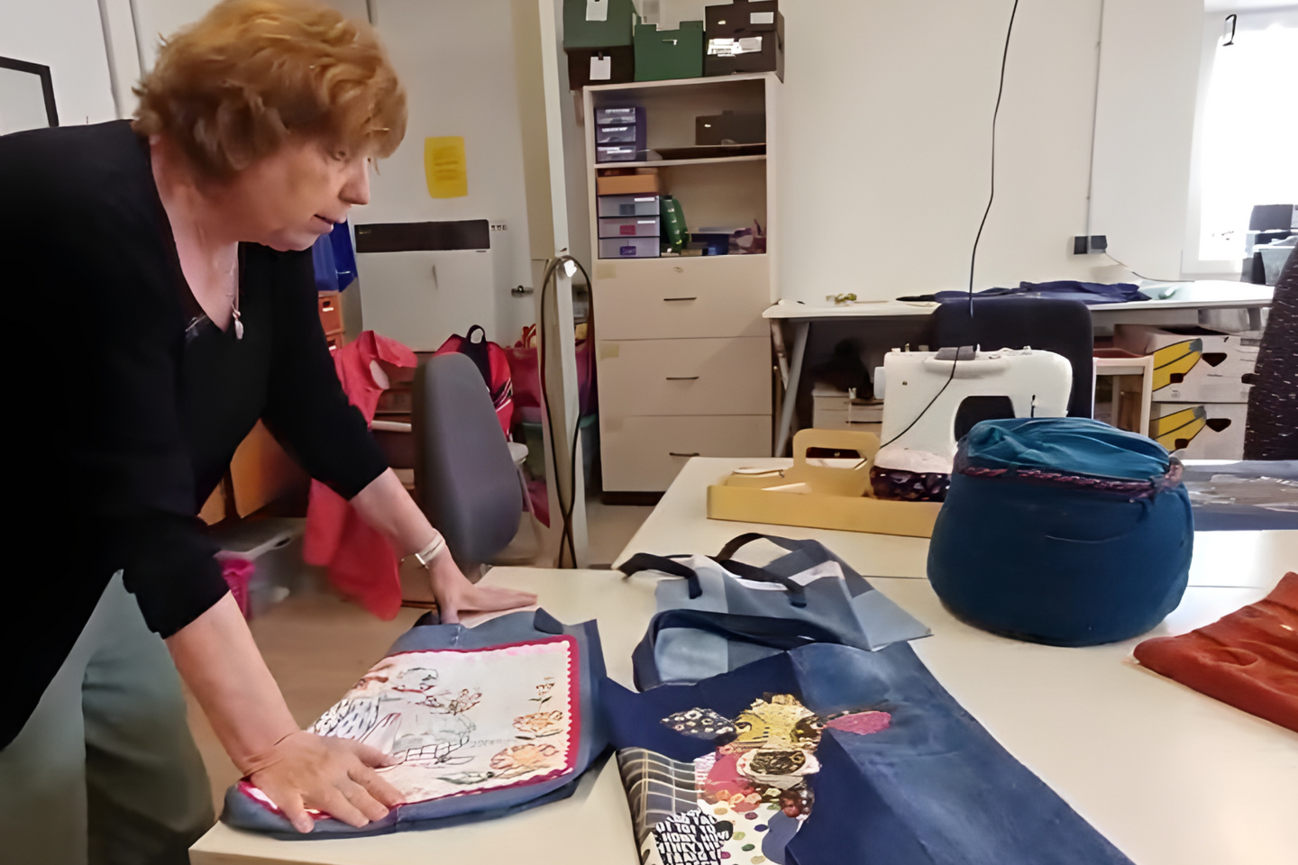 Eine Mitarbeiterin des kbo-SPZ zeigt einige Upcycling-Projekt in der Nähstube